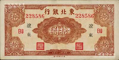 民國三十四年（1945年）東北銀行紅色拾圓長號券，遼東地名，下邊有“東方印刷局印制”廠銘，且票內(nèi)有英文水印，九至九五成新