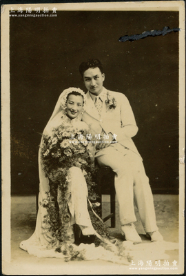 民國時期（1938年）“著名影星周璇”與“著名作曲家嚴華”原版結婚照1張，尺寸56×84mm；嚴華曾是三十年代著名電影作曲家，又擅長自彈自唱，昔年在黎錦暉的“明月歌舞團”，他與周璇對唱《桃花江》而轟動全國，被譽為“桃花王子”，1938年與周璇結婚，復于1941年離婚，之后棄藝從商，至1992年在上海逝世，享年101歲；罕見且保存甚佳，敬請預覽